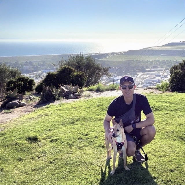 Tim with his dog from an ocean view hike